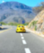 Descending into Oaxaca a "vocho amarillo" straddles the shoulder to allow vehicles to pass.