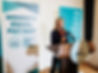 First Partner Jennifer Siebel Newsom standing at a speaker's podium for an Equal Pay Day event
