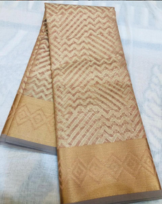 a gold saree with a wave pattern and a diamond border