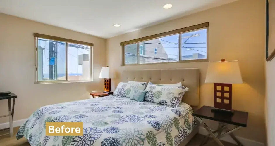 Master bedroom in San Diego Airbnb coastal rental with queen bed, beige upholstered headboard, and large windows with