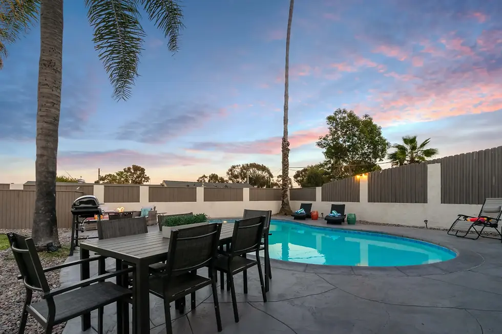 STR San Diego property backyard with resort-style pool, lounge seating, and modern patio fence at sunset