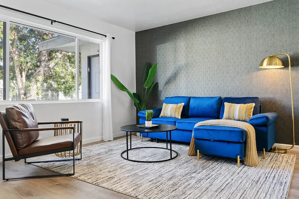 Modern Mission Beach CA short-term rental living room with blue sectional sofa, natural light, and contemporary coastal decor