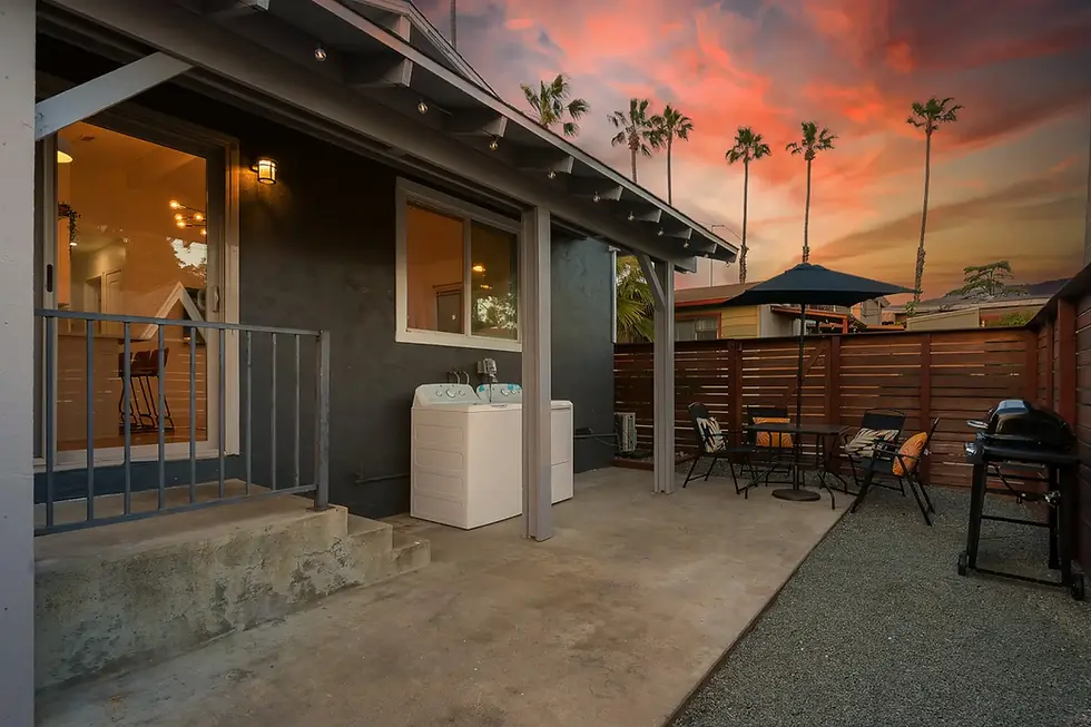 Modern San Diego backyard patio with outdoor entertaining space, hot tub, BBQ grill, and wooden privacy fencing at sunset