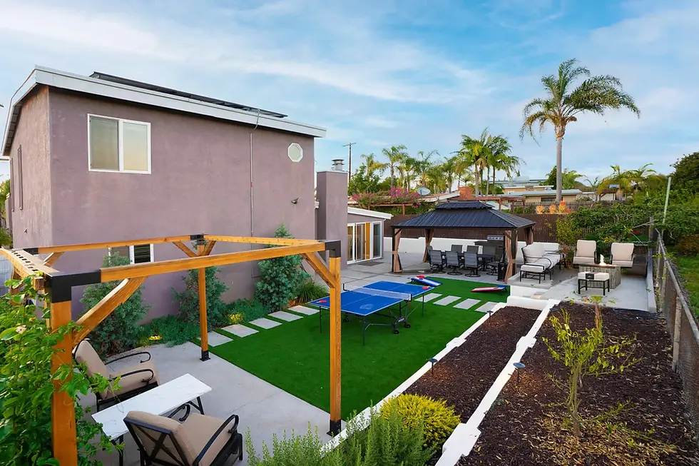 Modern San Diego backyard with purple home, pergola, artificial turf, and gazebo for outdoor entertaining and property appeal