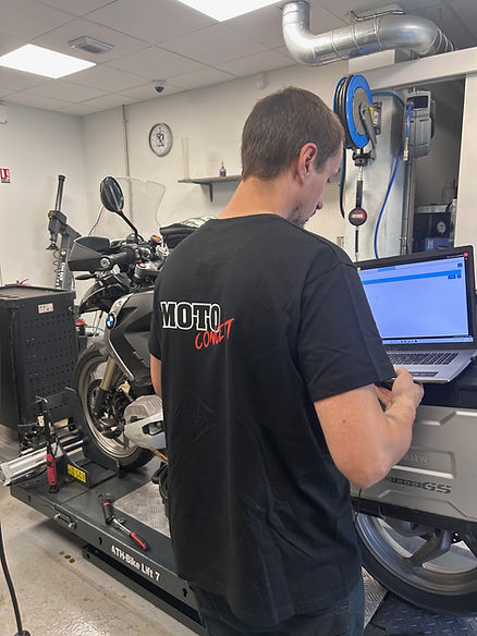 mécanicien répare moto bmw dans son garage