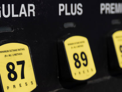 Close-up of three gas pump buttons labeled "Regular," "Plus," and "Premium" with yellow markers showing octane numbers 87, 89, and 93.