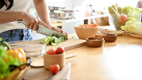 Person preparing salad by cutting lettuce.