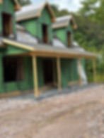 Classic Cape Cod house under construction with dormers. Front Porch framing.