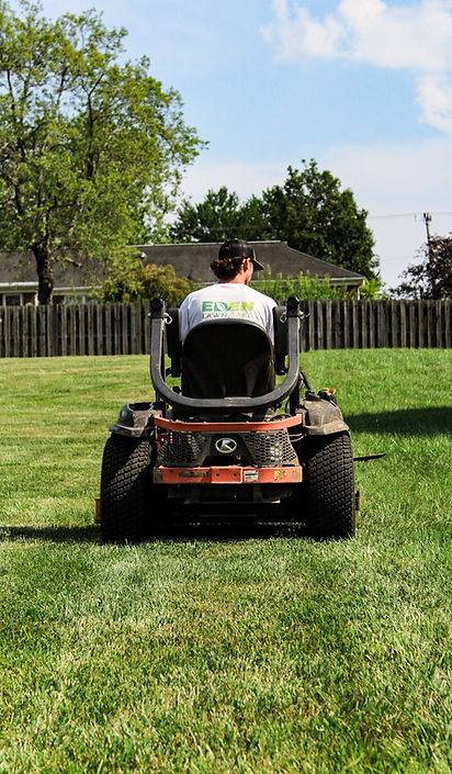 Professional Lawn Care Worker Mowing Grass on Zero Turn Mower