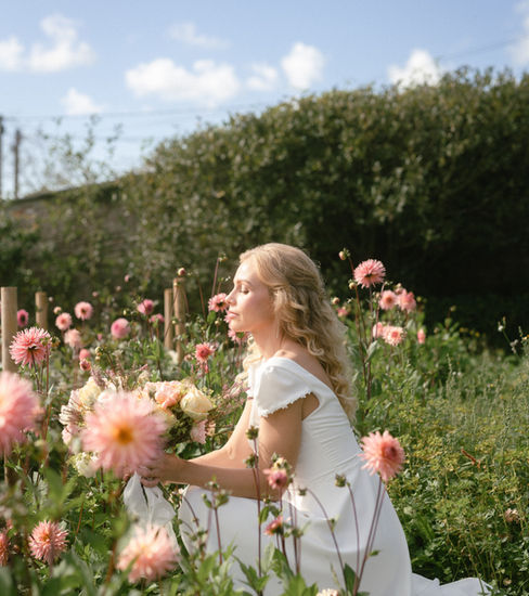Discover Flora by Sophie Rose Bridal, a romantic wedding dress perfect for garden, countryside and outdoor weddings. Featuring a wide V neckline, delicate capped puff sleeves, floral appliqué and a button-detailed V-back, its flowing half-circle skirt completes the look. Handcrafted to your measurements in Hampshire.
