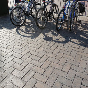bicycles;sunlight;shadows;locked;bike-rack;block pavement