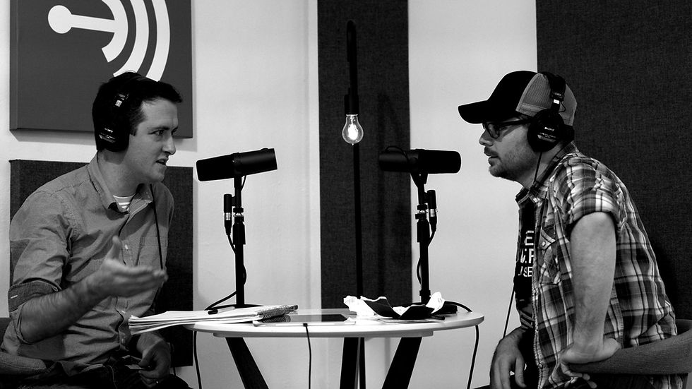 Two men talk to each other into microphones