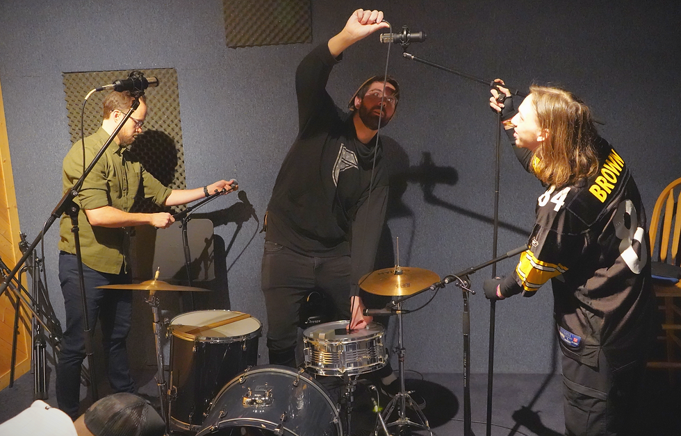 Audio in Media students placing overhead microphones above a drum kit