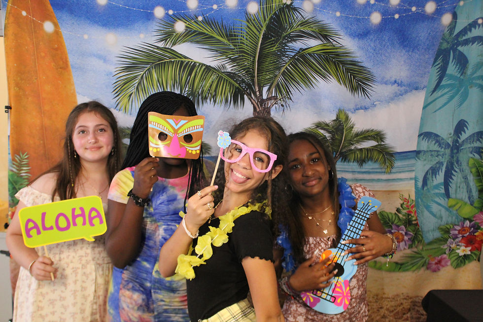 Close-up view of a tropical-themed photo booth with palm leaves and floral props
