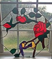 Square stained glass piece featuring two birds on a vine of roses. Spring love is in the air with these two birds in purple and yellow.