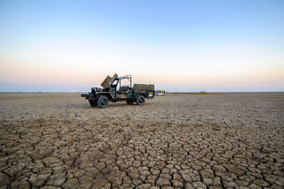 a jeep is parked in the middle of a dry desert