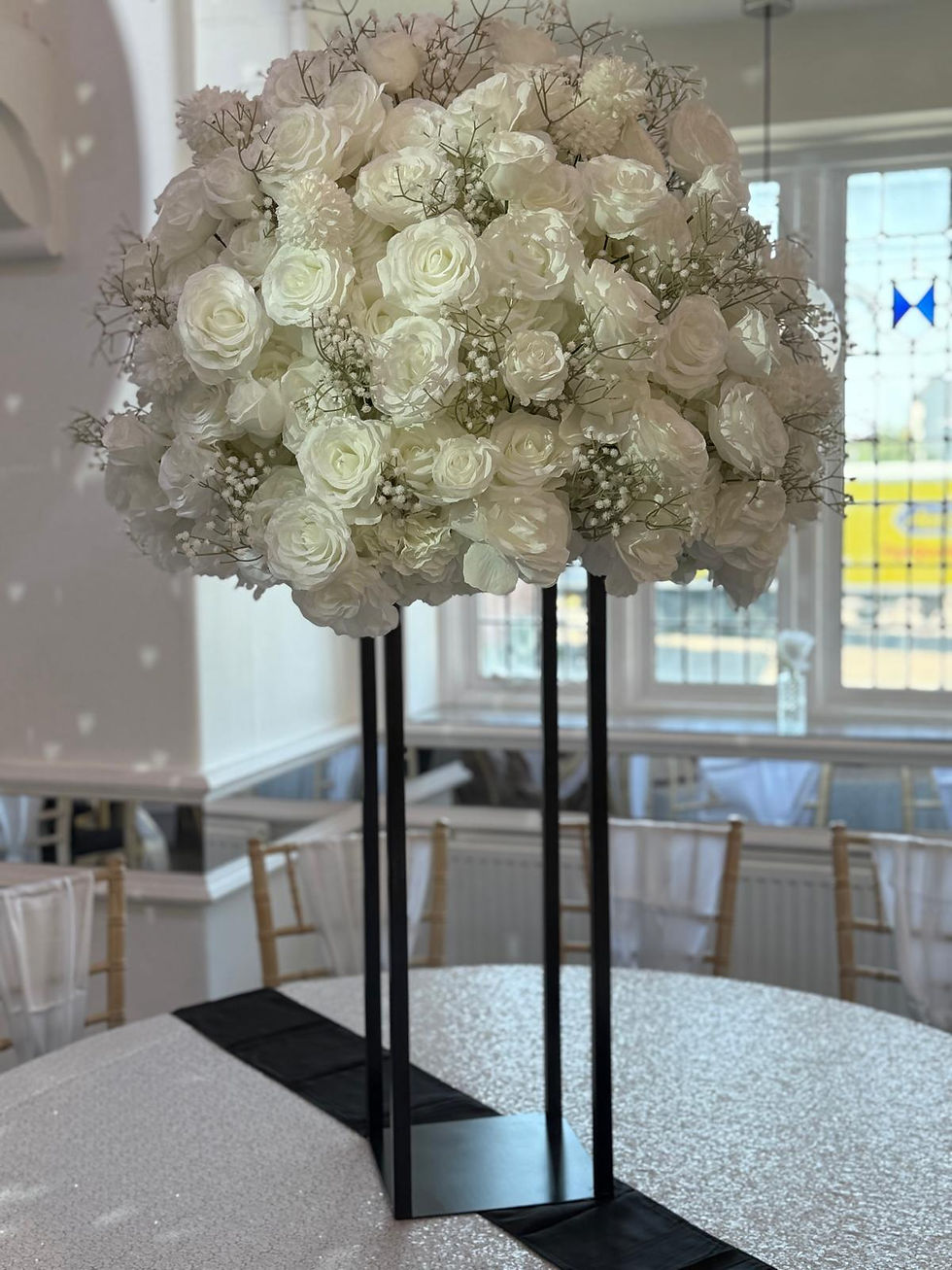 White floral bomb centrepieces on black stands — The Venue by White