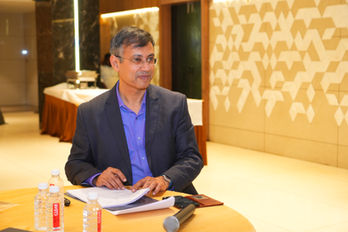 Program coordinator from Pranavam Wellness standing near conference tables.