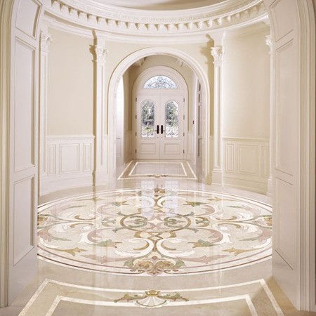 Beige marble floor with mosaic borders and hardwood flooring in chevron pattern in a stylish interior.