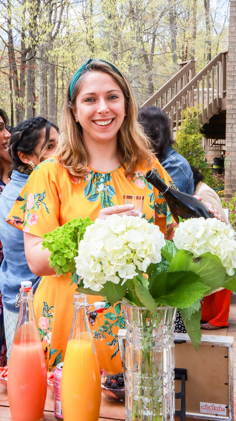 Woman pours wine at outdoor gathering