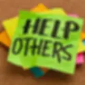 A pile of Post-it notes. The top one is neon green and has the words "help others" written in black sharpie. This signifies that SEO is about helping others first.