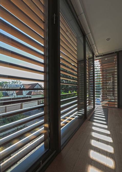 Internal view of full-height glazing and timber brise-soleil facade at Squitchey Lane, an award winning extension and renovation of an Oxford home by Matthew Clay Architects