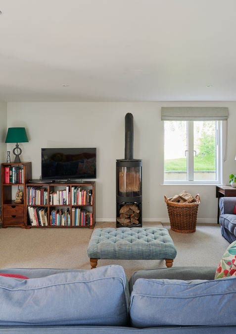 Modern living room and wood burning stove at Benmead, Wiltshire, designed by Matthew Clay Architects