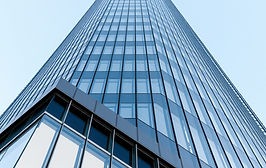 A clean, upward-angle shot of a modern glass and steel skyscraper or a sleek commercial bu