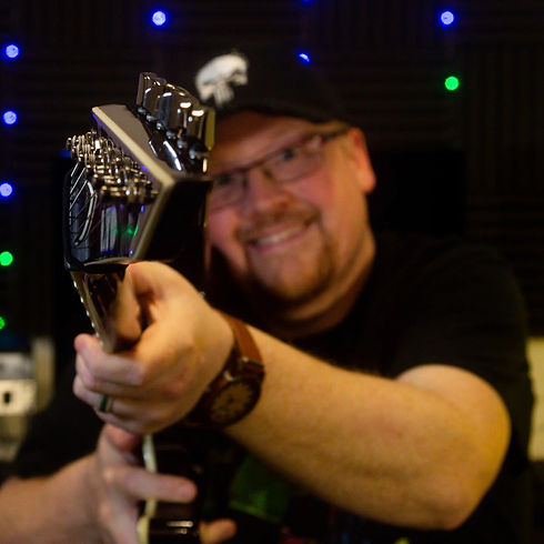 Pete pointing a guitar at the camera in the recording studio