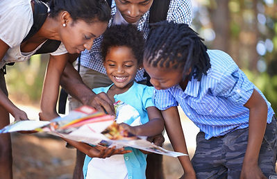 Parents and children outside looking at a foldable map