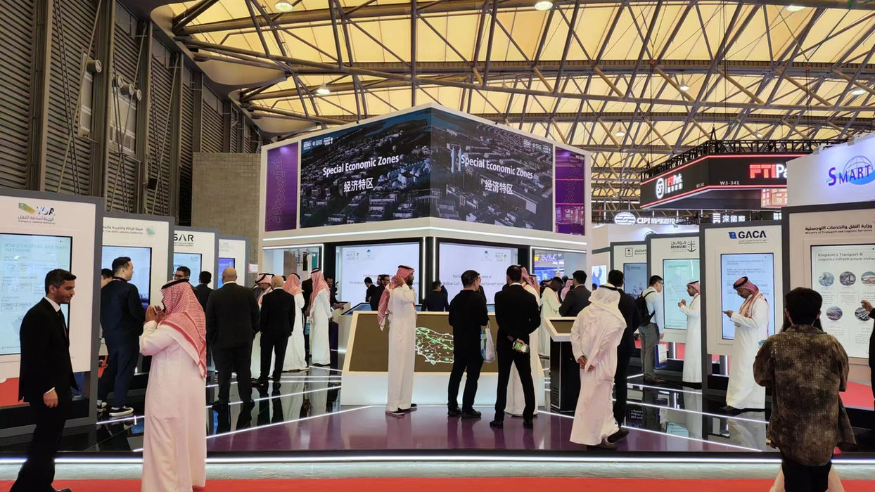 Crowd viewing a presentation with text, an exhibition at an event.