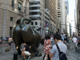 Tourists rubbing the charging bull for good luck