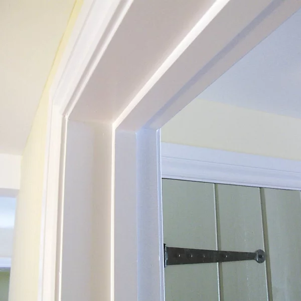 Metsä Wood primed softwood door lining set fitted in a domestic interior, showing white-primed head and jamb with architrave detail and a glazed internal door