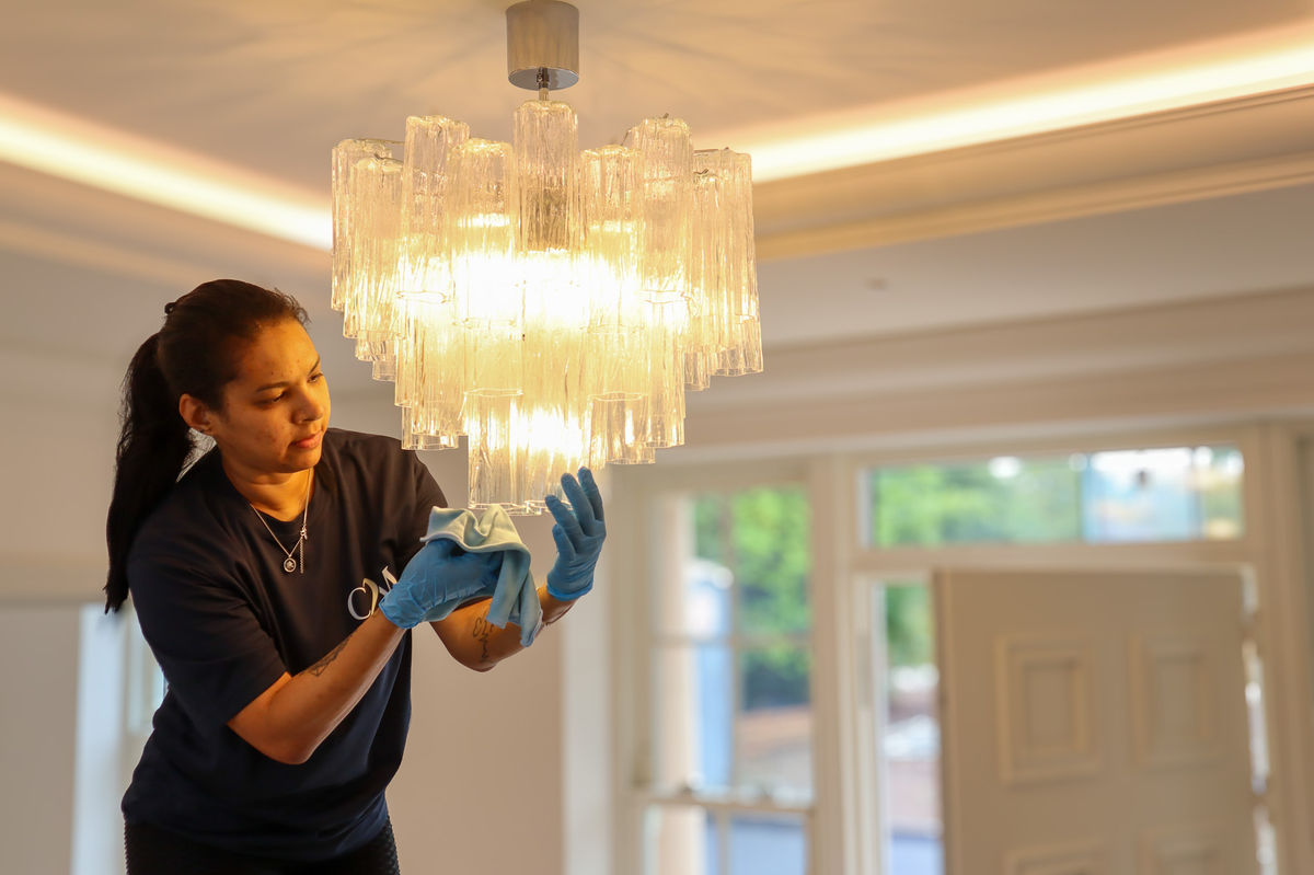 Cleaners2Match cleaner polishing a chandelier during a deep clean