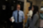 Hollywood director Jeff Fisher, wearing a tie and headphones, is engaged in conversation with a woman.