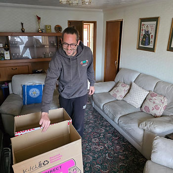 Leicester Moving Company team clearing items from a lounge during a house clearance in Leicester.