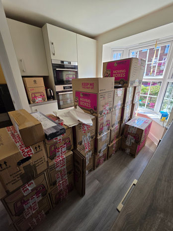 Fully packed and labelled moving boxes stacked in kitchen after day one of two-day move.