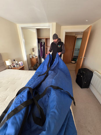 Team member folding mattress protection after unloading at the new Blaby apartment.