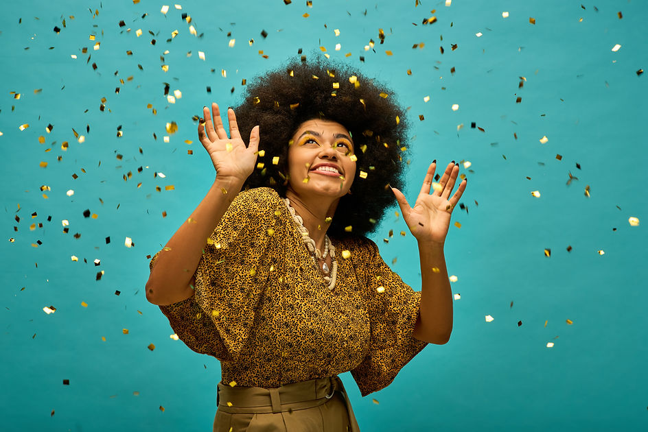 A stylish African American woman stands in front of a blue background, joyfully surrounded