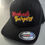 Thumbnail: Black Machado Burgers hat with logo and FLEXFIT tag on display