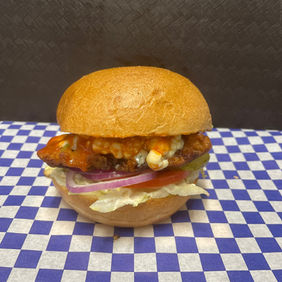Delicious burger on a checkered surface with fresh lettuce and tomato