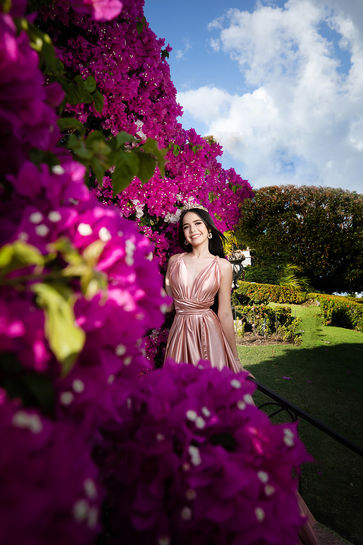 Mujer en vestido rosa junto a buganvilias