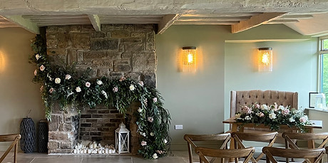 The beautiful fireplace and ceremony table florals at The Willows at the Woodman's