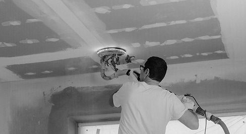 Worker sanding ceiling on stilts_edited.jpg