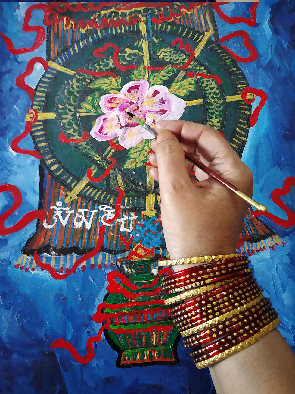 Thumbnail: Hand with bangles painting a lotus on a mandala