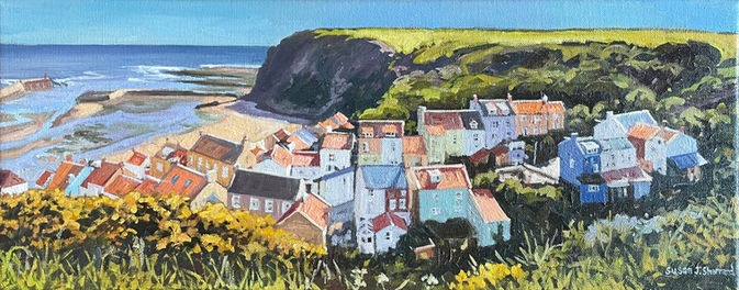 A panoramic view looking down to Staithes Harbour and Church Street on a bright summer morning.