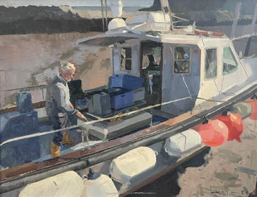 A fisherman with yellow boats washing the deck of his modern fishing boat on a sunny day.