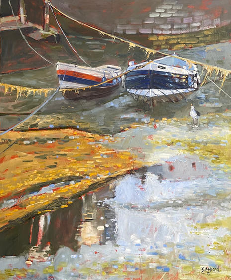 A view of two traditional fishing boats at low tide in Staithes Beck.