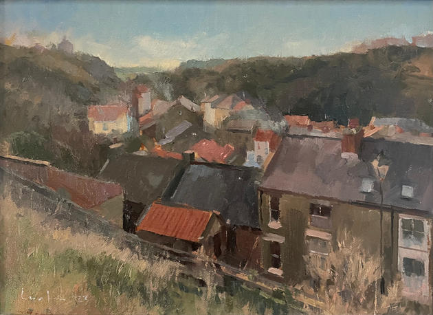An atmospheric view of Staithes looking inland over the village, rooftops and smoke.