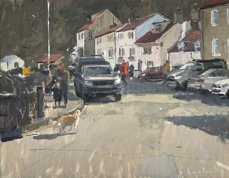 A sun drenched view of Staithes harobourside and a receding view of cottages. An alert dog casts a shadow in the foreground.